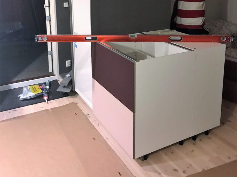 Integreret køkken og garderobe med linoleums fronter i farverne burgundy og powder