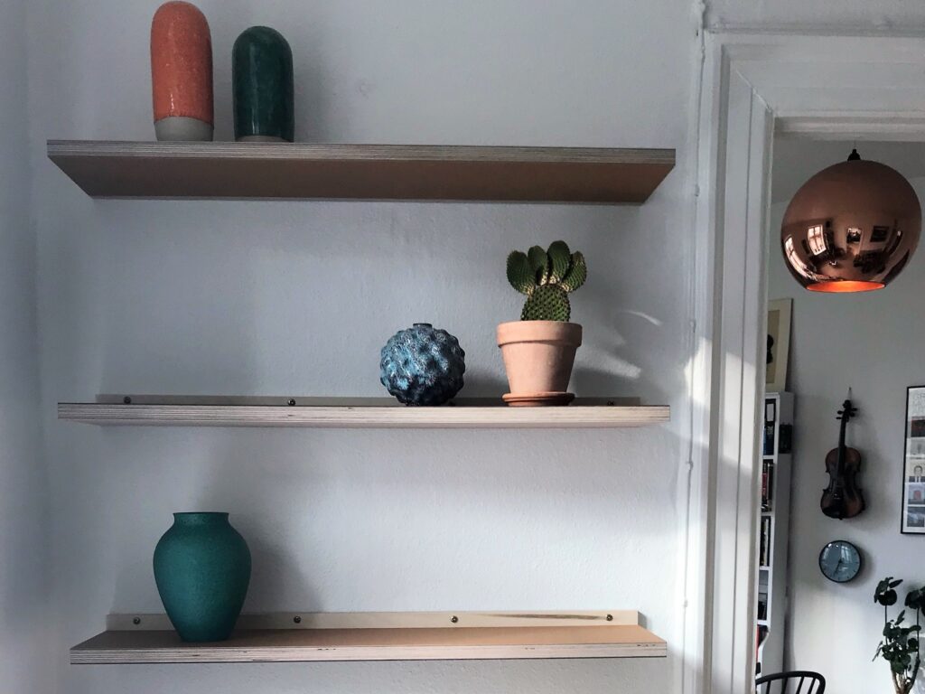 3 hylder i linoleum på top og bund i farverne powder og burgundy