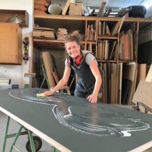 Maria lægger sidste hånd på en linoleums bordplade i farven ash