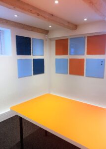 Ny indretning i mødelokale med tavler på væggen og orange bord